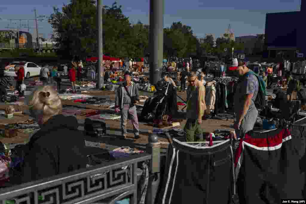 Cazadores de antigüedades, coleccionistas y muchos otros buscan entre filas que parecen interminables de baratijas y artículos desgastados por el paso del tiempo, en el mercado de Pochaina, en Kyiv. (AP Foto/Jae C. Hong)