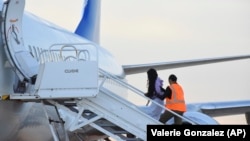 Migrantes venezolanos abordan un avión con destino a su país natal en Harlingen, Texas, el miércoles 18 de octubre de 2023. (AP Foto/Valerie Gonzalez)