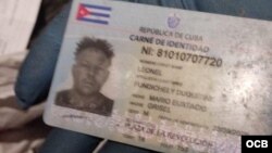 Soldado ucraniano sostiene el documento de identidad de uno de los cubanos muertos en Ucrania.