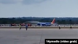 El avión accidentado, en la pista del aeropuerto José Martí de La Habana, mientras los bomberos apagan el fuego en la turbina. (Captura de video/14ymedio)