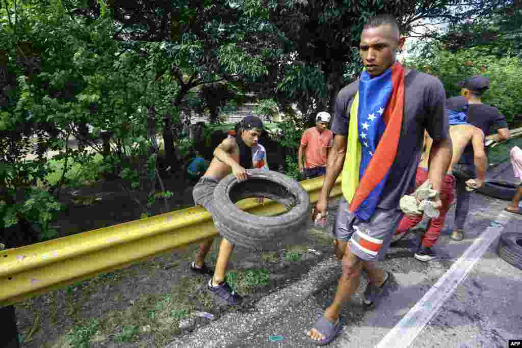 Manifestantes llevan neumáticos usados y piedras durante protesta contra el gobierno de Nicolás Maduro en Valencia, estado de Carabobo, Venezuela, 29/07/2024, AFP. (Foto de Juan Carlos HERNANDEZ/AFP)