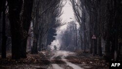 Residente camina por la una calle de Bakhmut, Ucrania, bajo el sonido de las alarmas aéreas el 27 de febrero de 2023 (FotoDIMITAR DILKOFF / AFP)