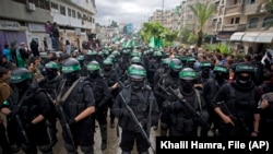 Militantes armados de Hamás conmemoran otro aniversario del grupo en la ciudad de Gaza, en diciembre de 2014. (AP/Khalil Hamra, File)