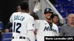 Jorge Soler y Yuli Gurriel, de los miami Marlins, celebran durante un juego contra los Nacionales de Washington. (AP Photo/Marta Lavandier)