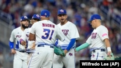 El lanzador puertorriqueño José De León, segundo desde la derecha, es felicitado por sus compañeros al final de la sexta entrada del juego del Clásico Mundial de Béisbol contra Israel.