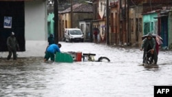 Personas en una calle después de que las fuertes lluvias provocaran inundaciones en Camagüey, Cuba, el 9 de junio de 2023. 