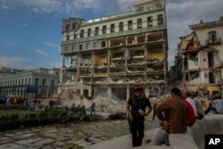 Personas observando los trabajos de rescate luego de una explosión letal que dañó el hotel Saratoga, en La Habana, el viernes 6 de mayo de 2022. (AP Foto/Ramón Espinosa)