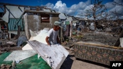 Un hombre entre los escombros después del paso del huracán Ian en La Coloma, Pinar del Río. Imagen tomada el 13 de octubre de 2022 (Yamil Lage/AFP).