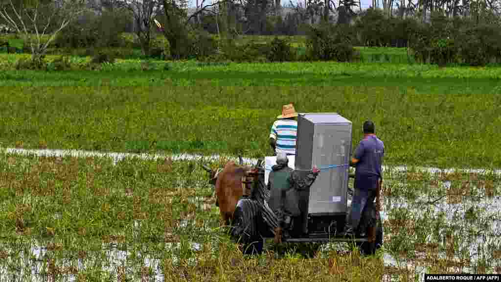 Cubanos transportan un refrigerador en San Juan y Martínez, provincia de Pinar del Río, Cuba tras el paso del huracán Ian, el 27 de septiembre de 2022. -