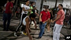 Un policía vestido de civil reprime a una manifestante durante una protesta pacífica en El Vedado, La Habana. La represión política y la falta de oportunidades económicas seguirán impulsando la migración desde Cuba a EEUU, dice informe.