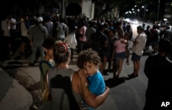 Una madre carga a su niño en brazos durante una protesta pacífica, en La Habana, Cuba, este sábado 1ro de octubre. (AP/Ramon Espinosa)