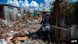 Una mujer camina por una calle llena de escombros en La Coloma, provincia de Pinar del Río, Cuba, tras el paso del huracán Ian.