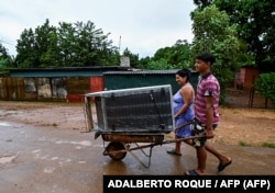 Una famila resguarda sus pertenencias en Batabanó.