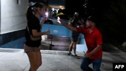 Un agente vestido de civil detiene a un a joven manifestante durante las protestas del sábado, 1ro de octubre, en El Vedado, La Habana. (YAMIL LAGE / AFP)