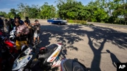 Cubanos con motos eléctricas en una avenida de La Habana. 