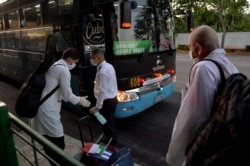 Médicos cubanos retornan a la isla procedentes de Italia, adonde fueron enviados por gobierno en medio de la crisis de coronavirus. (Yamil LAGE / POOL / AFP)