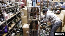 Un empleado limpia los destrozos en una tienda tras el sismo de 7.1 que sacudió este sábado el área de Fukushima, Japón. (Kyodo/vía REUTERS)