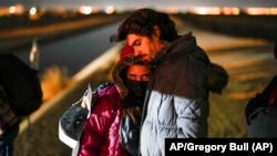 Una pareja de Cuba espera ser procesada para solicitar asilo después de cruzar la frontera, cerca de Yuma, Arizona. (AP/Gregory Bull/Archivo)