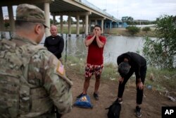 Migrantes cubanos interceptados por agentes de la Guardia Nacional estadounidense tras cruzar a nado el Río Bravo, en Eagle Pass, Texas. (AP/Dario Lopez-Mills)