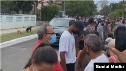 El agente Camilo, de perfil con mascarilla azul y camisa roja, azote de la oposición cubana.