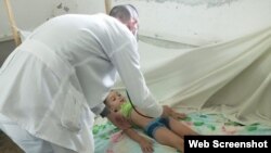 Un médico diagnostica a un niño en medio de un brote de dengue, en Colón, Matanzas. (Captura de imagen/Girón)