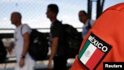 Migrantes cubanos hacen fila en el puente Santa Fe, de Ciudad Juárez, a la espera de agentes de seguridad fronteriza de EEUU para solicitar asilo. (REUTERS/Jose Luis Gonzalez)