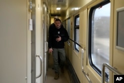 El presidente de Ucrania, Volodymyr Zelenskyy, camina por el pasillo del tren camino de la región de Sumy a Kyiv, Ucrania, el martes 28 de marzo de 2023. (AP/Efrem Lukatsky)