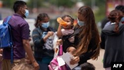 Una familia de migrantes arriba a Eagle Pass, Texas, en la frontera sur de EEUU, el 22 de mayo de 2022. (Allison dinner / AFP)