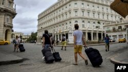 Turistas caminan hacia el Hotel Kempinski.