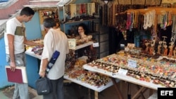 Dos hombres compran artesanías cubanas en La Habana (Cuba). 