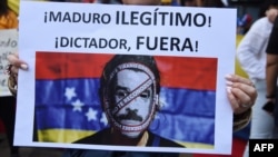 Manifestante muestra pancarta calificando de dictador a Maduro