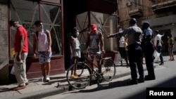 Un policía organiza una cola para comprar alimentos en La Habana. (REUTERS/Alexandre Meneghini)