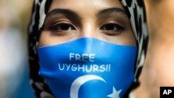 Una mujer en Berlín exige la libertad de los uigures detenidos en Xinjiang, China, el 1 de septiembre de 2020, durante la visita del canciller chino, Wang Yi. (AP Photo/Markus Schreiber).