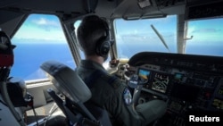 Un miembro de la Guardia Costera de los Estados Unidos pilota un avión HC-144 Ocean Sentry durante una misión de patrullaje en el Estrecho de la Florida, el 17 de julio de 2021. (REUTERS / Marco Bello).