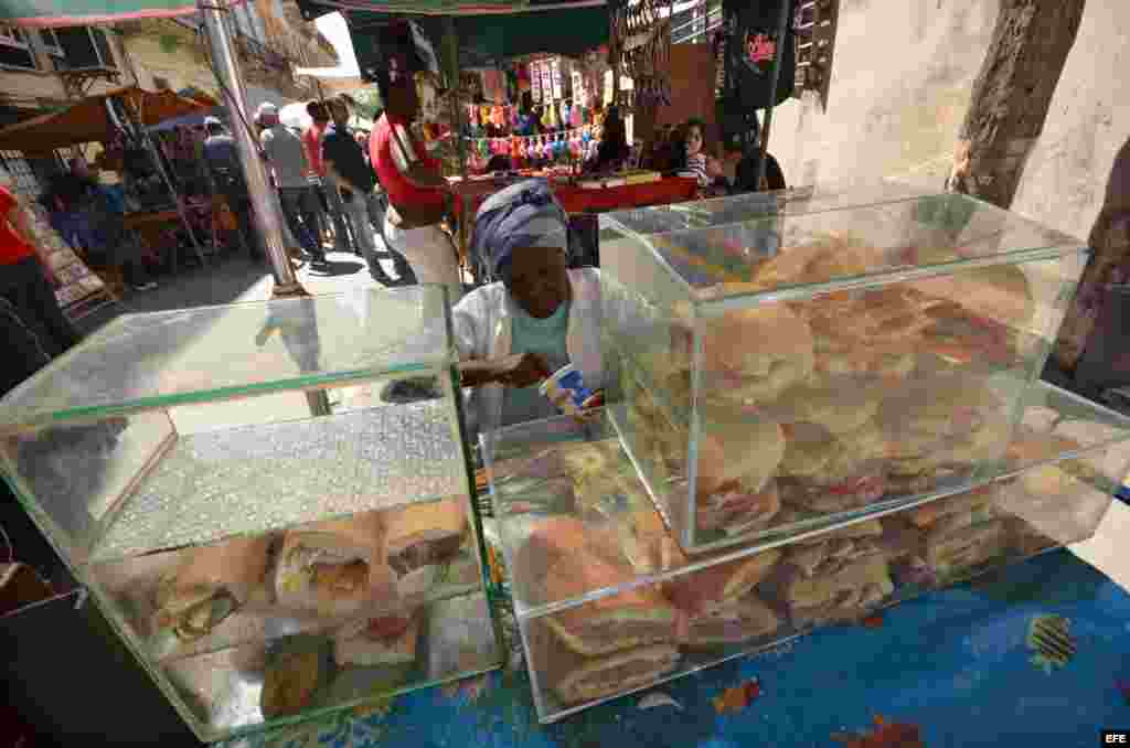 Una mujer vende comidas rápidas en su negocio independiente. 