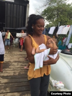 Una madre sostiene a un bebé a la hora del baño diario en Turbo, Colombia. Foto: R. Quintana.