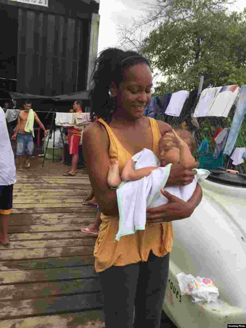 Una madre sostiene a un bebé a la hora del baño diario en Turbo, Colombia. Foto: R. Quintana.