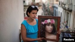 Heissy Celaya posa con un retrato de su hija Amanda Celaya, detenida por la policía durante una protesta, en La Habana. Fotografía tomada el 20 de julio de 2021. REUTERS / Alexandre Meneghini