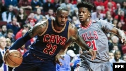 LeBron James (i) de Cavaliers ante la marca de Jimmy Butler (d) de Bulls.