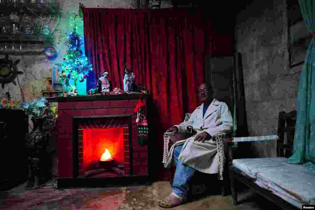 Angel Ochoa, de 65 años, posa para una foto en su casa con adornos navideños en Rincón, Cuba, el 16 de diciembre de 2023. REUTERS/Alexandre Meneghini