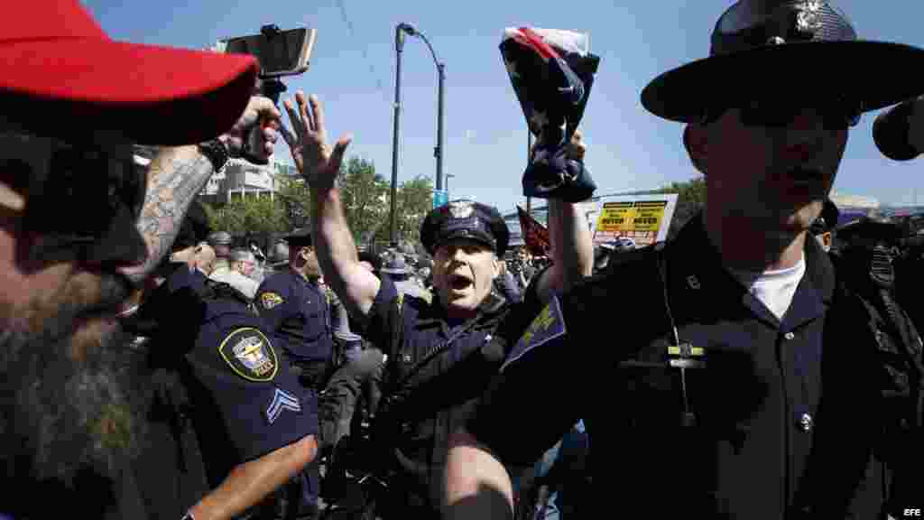 Un grupo de policías intentan despejar la entrada a Quicken Loans Arena, sitio donde se realiza la Convención Nacional Republicana.