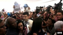 Los opositores cubanos Manuel Cuesta Morúa (i) y Lilianne Ruiz (c) son hostigados por miembros de la delegación oficialista cubana a la entrada del "Foro de la sociedad civil y actores sociales" de la VII Cumbre de las Américas.