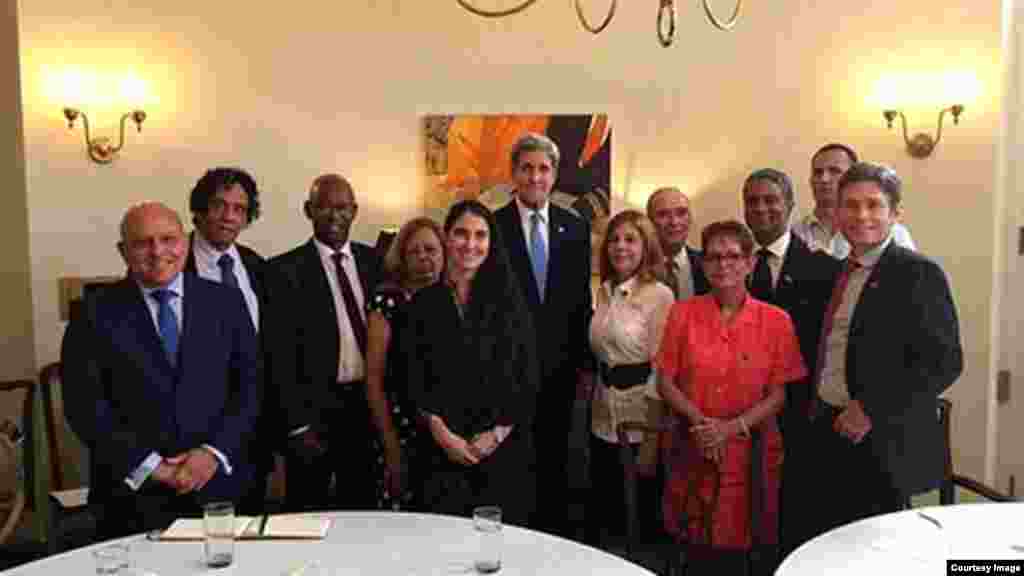 Activistas de la sociedad civil se fotografían con John Kerry en la residencia de DeLaurentis.