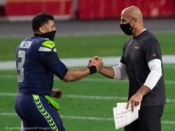 Robert Saleh (dcha.) saluda a Russell Wilson, mariscal de campo del equipo Seattle Seahawks después de un partido. (© Jennifer Stewart/AP Images)