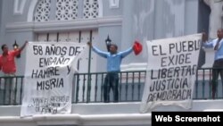 Opositores enarbolan carteles en contra del Gobierno cubano en la catedral de Santiago de Cuba.