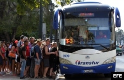 Turistas abordan un autobús en La Habana.