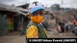 Un niño lleva una mascarilla mientras camina por el asentamiento de Mathare en Naironi, Kenya. Foto: © UNICEF/Alissa Everett.
