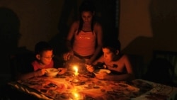 Niños comen a la luz de una vela durante un apagón en Cuba en el año 2009. AFP PHOTO/STR / AFP PHOTO / STR