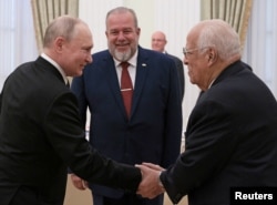 Vladimir Putin, le da la mano al viceprimer ministro cubano, Ricardo Cabrisas Ruiz, mientras el primer ministro cubano, detrás, Manuel Marrero Cruz, durante una reunión en el Kremlin en Moscú, Rusia, el 14 de junio de 2023. Sputnik/Mikhail Metzel/Pool vía REUTERS