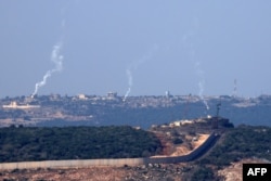 Se disparan bengalas desde el norte de Israel sobre la aldea fronteriza de Aita al-Shaab, en el sur del Líbano, el 28 de octubre de 2023. (Foto de FADEL SENNA / AFP)